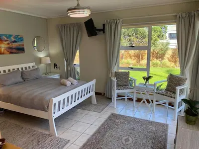 a bedroom with a bed and a table and chairs at Sunset Breeze in Cape Town