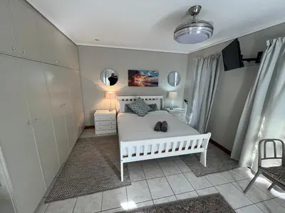a bedroom with a white bed with two shoes on it at Sunset Breeze in Cape Town