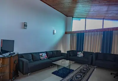 a living room with a couch and a tv at Wilcuma Lodge in Plattekloof