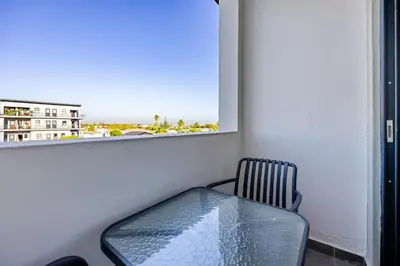a glass table in a room with a window at Modern 2 bed, 2 bath, 14B- Blouberg in Bloubergstrand