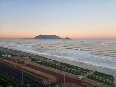 a view of a beach with a mountain in the distance at Luxury Beachfront-LaVista with Mountain & Ocean views in Bloubergstrand