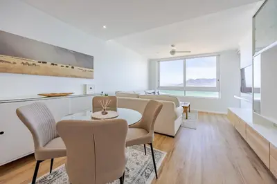 a living room with a table and chairs at Luxury Beachfront-LaVista with Mountain & Ocean views in Bloubergstrand
