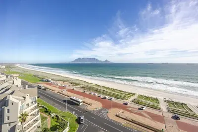 a view of the beach and the ocean in cape town at Luxury Beachfront-LaVista with Mountain & Ocean views in Bloubergstrand