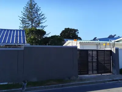 a fence with a solar panel on top of a house at Eneco Lodge in Cape Town
