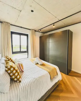 a bedroom with a large bed and a window at Olive Apartment on Bridgewaters in Cape Town