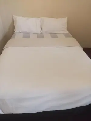 a white bed with white sheets and pillows at Halibut Suite in Strand