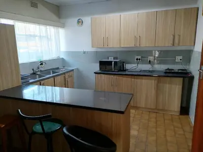 a kitchen with wooden cabinets and a counter top at 72 Hamilton the trout lodge in Goodwood
