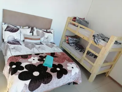 a bedroom with a bed and bunk beds in it at 72 Hamilton the trout lodge in Goodwood