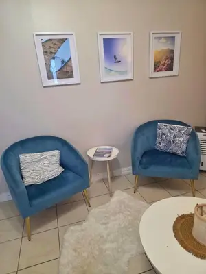 two blue chairs and a table in a room at Spring Tide Beach Flat Child Petfriendly Hot Tub in Bloubergstrand