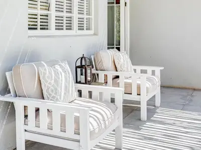 two white chairs sitting on a porch at Vineyard House in Worcester