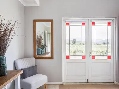 a white room with a mirror and a door at Vineyard House in Worcester