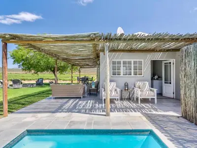 a patio with a swimming pool and a pergola at Vineyard House in Worcester