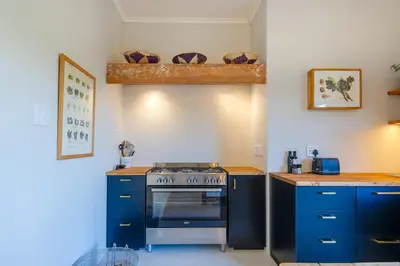 a kitchen with blue cabinets and a stove at Libertas House, Cheverells Farm in Grabouw