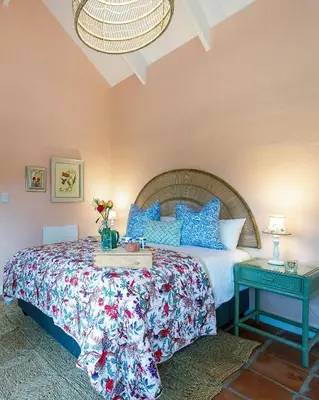 a bedroom with a large bed with blue pillows at Cripps Cottage, Cheverells Farm in Ouda Brug