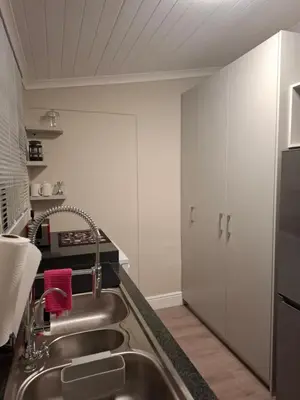 a kitchen with a sink and a refrigerator at Mukuru Okunene in Strand