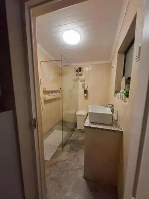 a bathroom with a sink and a glass shower at Mukuru Okunene in Strand