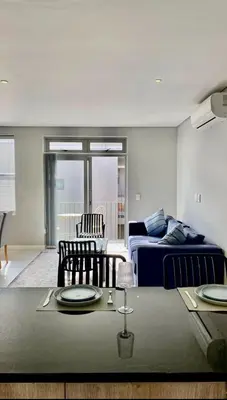 a living room with a bed and a table with plates on it at The Madge Self Catering in Paarl