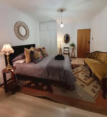 a large bed in a living room with a couch at River Front in Stellenbosch