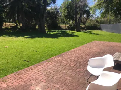 a pair of white chairs sitting on a brick patio at River Front in Stellenbosch