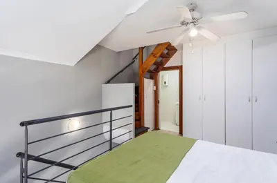 a bedroom with a bed and a ceiling fan at Century on Lake B31 by CTHA in Cape Town