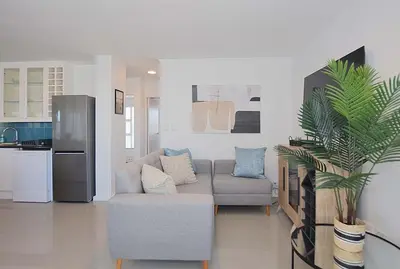 a living room with a couch and a kitchen at Ocean View B401 by CTHA in Bloubergstrand