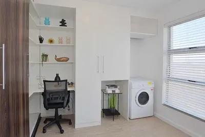 a home office with a desk and a washing machine at Ocean View B401 by CTHA in Bloubergstrand
