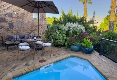 a patio with a table and chairs next to a pool at Kaniek - Guest Suite in Somerset West