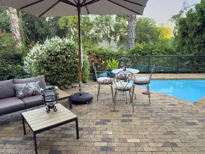 a patio with a table and chairs and an umbrella at Kaniek - Guest Suite in Somerset West