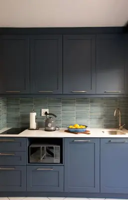 a kitchen with dark blue cabinets and a sink at Kaniek - Guest Suite in Somerset West