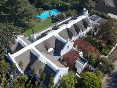 an overhead view of a large white house with a swimming pool at The Bothey House in Somerset West