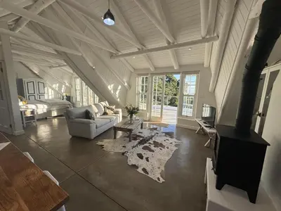 a living room with a couch and a table at The Bothey House in Somerset West