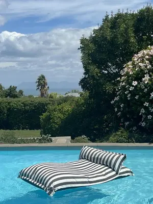 a striped pillow sitting in a swimming pool at The Bothey House in Somerset West