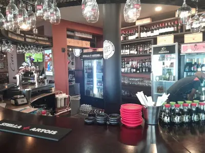 a bar in a restaurant with a counter with red cups at Sunset 786 Holiday Accommodation-Room 208 in Strand