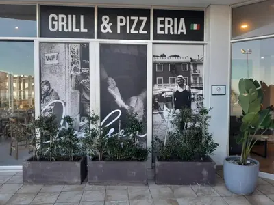 a store front with plants in front of it at Sunset 786 Holiday Accommodation-Room 208 in Strand