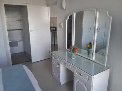 a bathroom with a counter with a mirror and a sink at Sunset 786 Holiday Accommodation-Room 208 in Strand