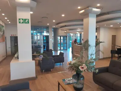 a lobby with couches and a table with flowers at Sunset 786 Holiday Accommodation-Room 208 in Strand
