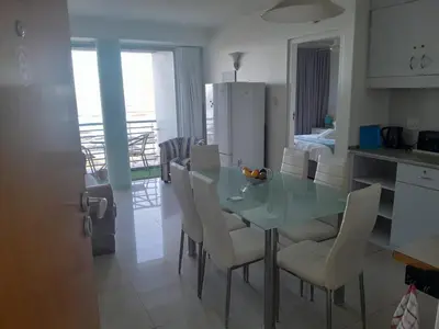 a kitchen and dining room with a table and chairs at Sunset 786 Holiday Accommodation-Room 208 in Strand