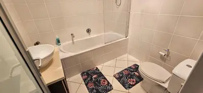 a small bathroom with a toilet and a sink at C-Onrus in Hermanus