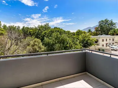 a balcony with a view of trees and buildings at FamoHof Apartments in Stellenbosch