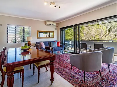 a living room with a table and chairs and a couch at FamoHof Apartments in Stellenbosch