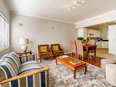 a living room with a couch and chairs and a table at FamoHof Apartments in Stellenbosch