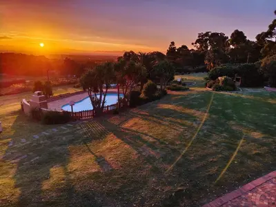 an aerial view of a yard with a pool at sunset at Into the Sunset Manor in Gordonʼs Bay