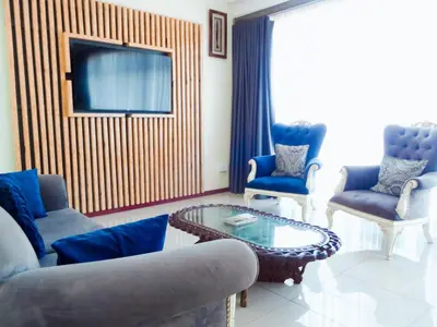a living room with blue chairs and a coffee table at Ngena Sleep and Go Goodwood in Goodwood