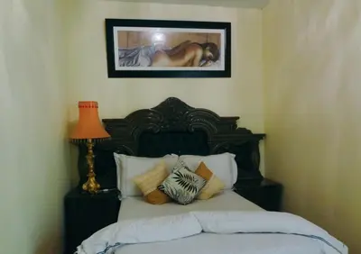 a bedroom with a bed with a picture on the wall at Ngena Sleep and Go Goodwood in Goodwood