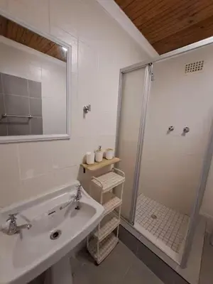 a white bathroom with a shower and a sink at Azzure Apartments 4 sleeper Crawford in Cape Town