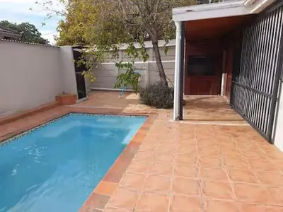 a swimming pool in front of a house at Azzure Apartments 4 sleeper Crawford in Cape Town