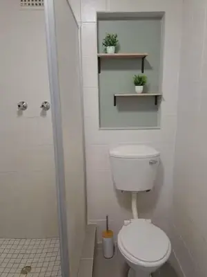 a white bathroom with a toilet and a shower at Azzure Apartments 4 sleeper Crawford in Cape Town