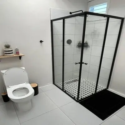 a bathroom with a toilet and a glass shower at 64 On Forest in Cape Town
