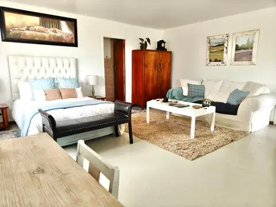 a living room with a bed and a couch at Sand Sittie in Sandbaai