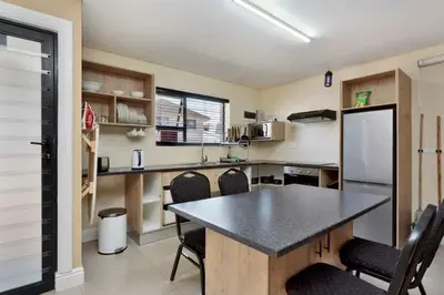 a kitchen with a table and chairs in a room at Camdene Guesthouse in Cape Town